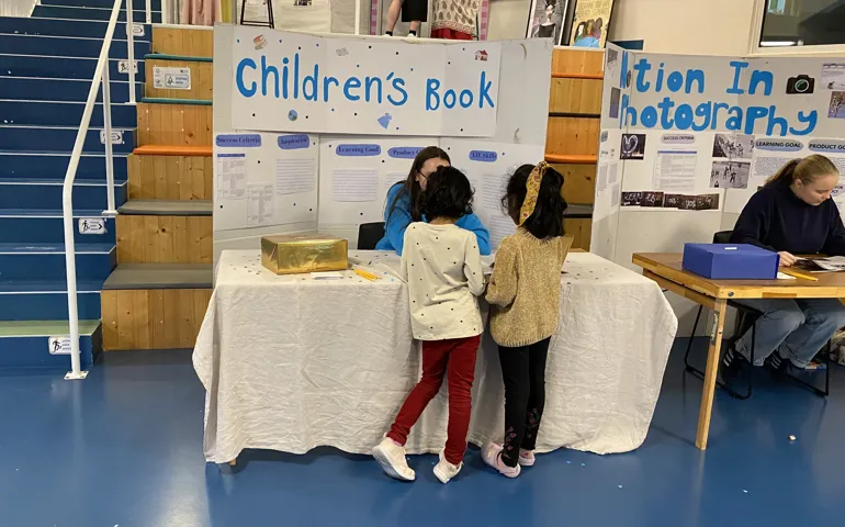 Barn framför monter "Childrens book". 