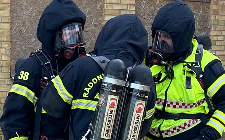 Brandmän i uniform och rökdykningsmask.