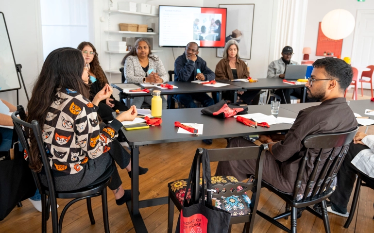Incubator participants sitting in a conference room with notebooks in front of them.