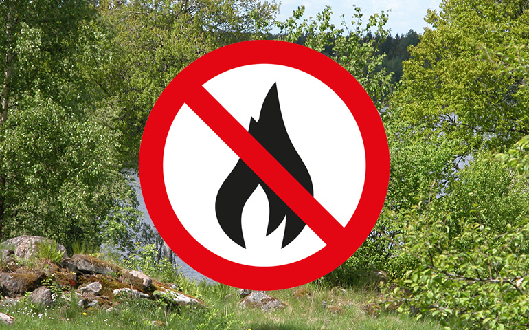 Skog och skylt med eldningsförbud