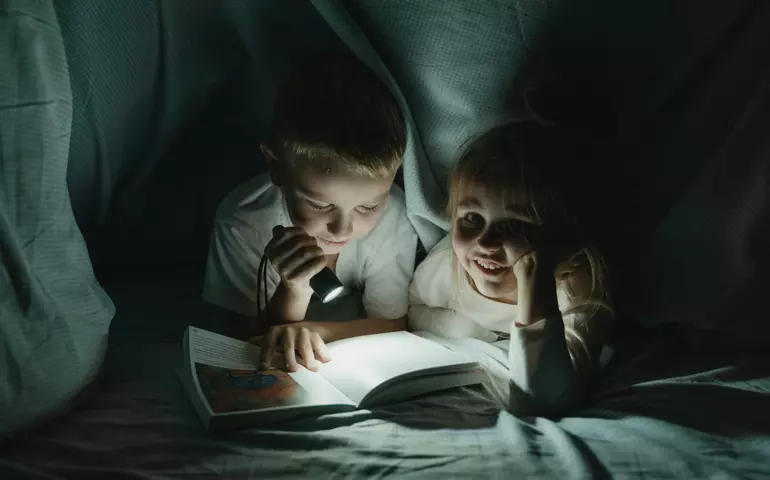 barn läser i en koja