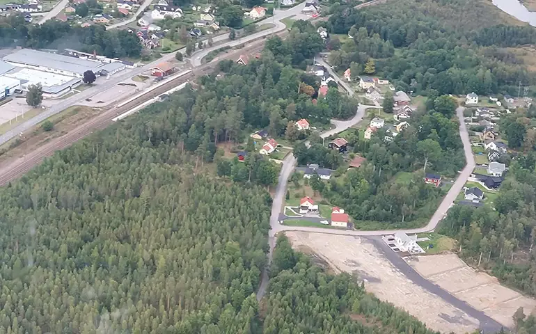 Flygbild med vy över området Kattesjön. Visar både hus och obebyggda tomter