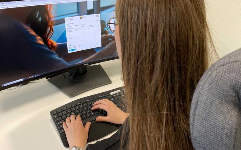 Kvinna skriver på dator och en skärmdump visas på visselblåsarfunktionen. 