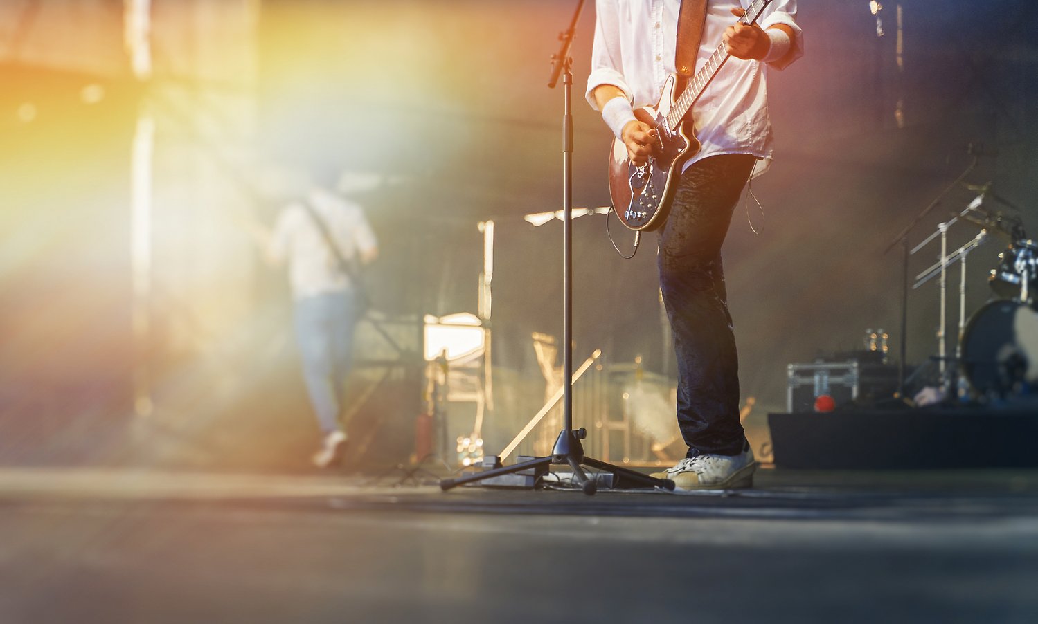 En person spelar gitarr på scen