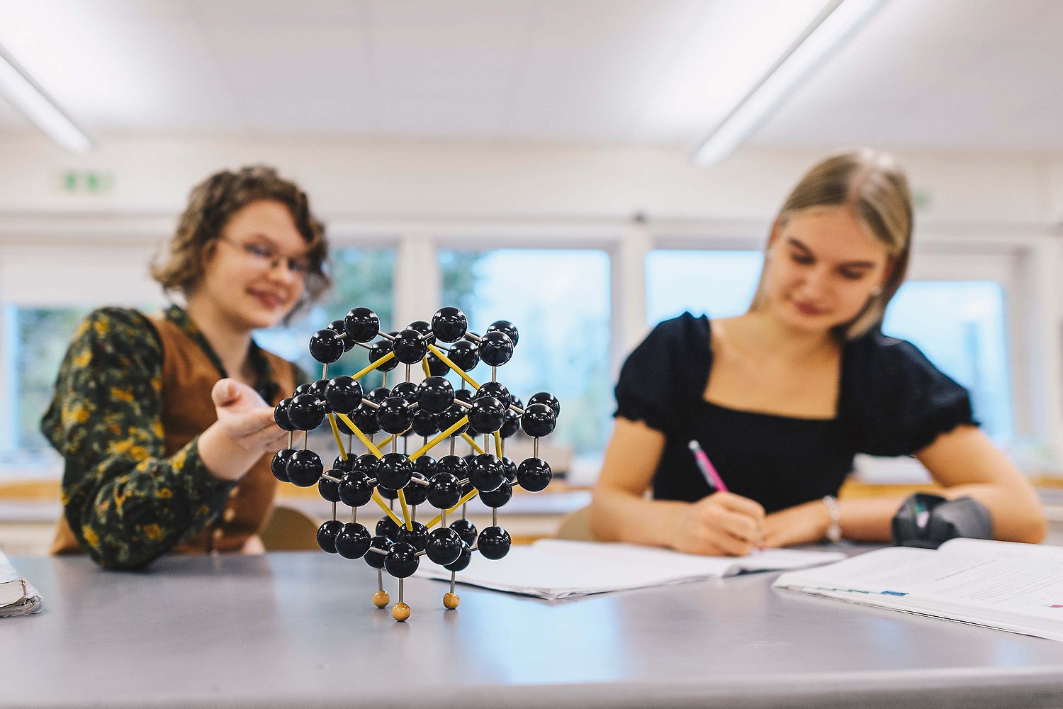 Två elever som sitter vid ett bord på en kemilektion