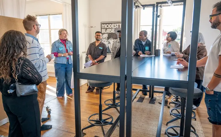 Tanja and the participants standing around a table during the house tour.