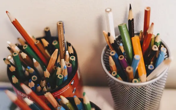 Tre burkar med färgglada pennor